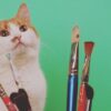 a cat posing with paint brushes